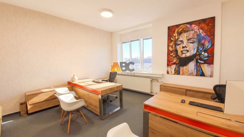 Offices with art on the walls and furniture with wood-patterned flooring.