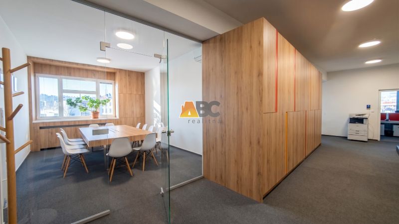 Offices with wood-patterned flooring and glass doors, furnished with chairs and a table.