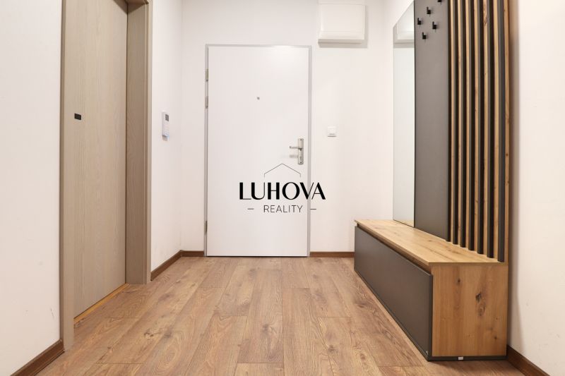 A hallway in a one-room apartment with a wooden decor floor and a wardrobe wall.