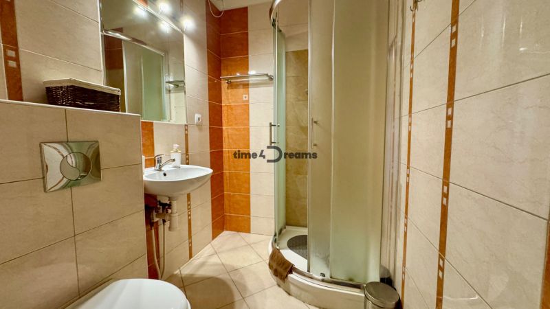Bathroom in a holiday apartment with ceramic tiles and a shower enclosure.