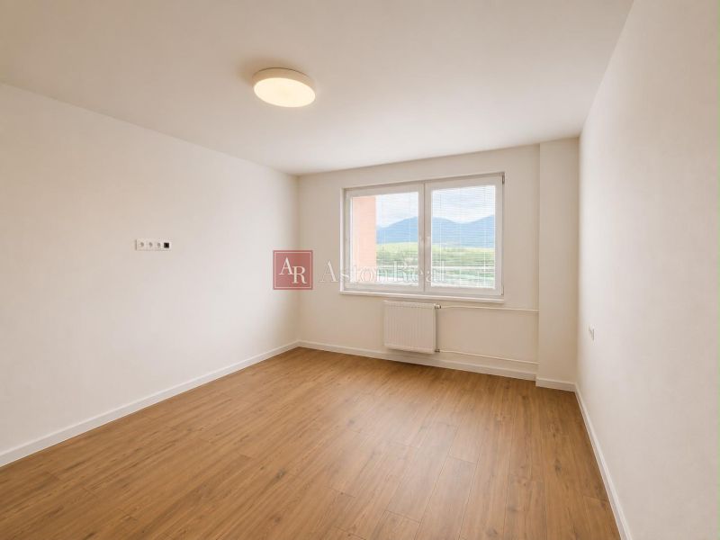 A bright room with a wooden decor floor in a 2-room apartment.