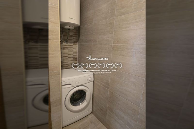 Washing machine and boiler in the bathroom of a two-room apartment with tiled walls.