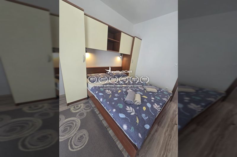 Bedroom in a 2-room apartment with a bed, wardrobe, and floor with wood decor.