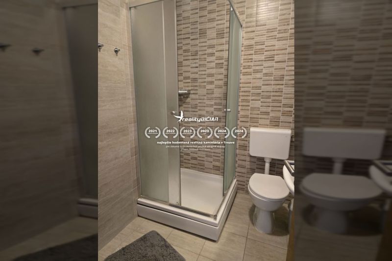 A bathroom with a modern shower and toilet in a 2-room apartment.