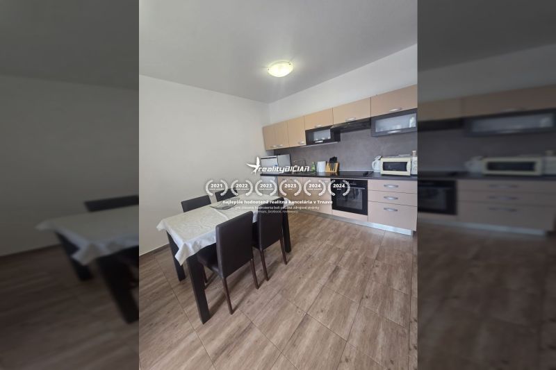 A kitchen with a wooden decor floor and a dining table in a two-room apartment.