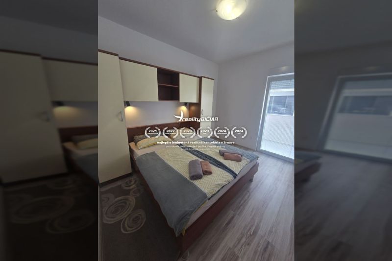 Bedroom with a double bed and a wooden decor floor in a 2-room apartment.