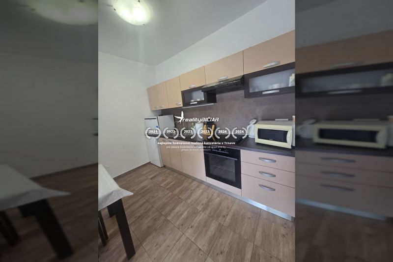 A kitchen in a 2-room apartment, with a modern kitchen unit and a floor with a wooden decor.