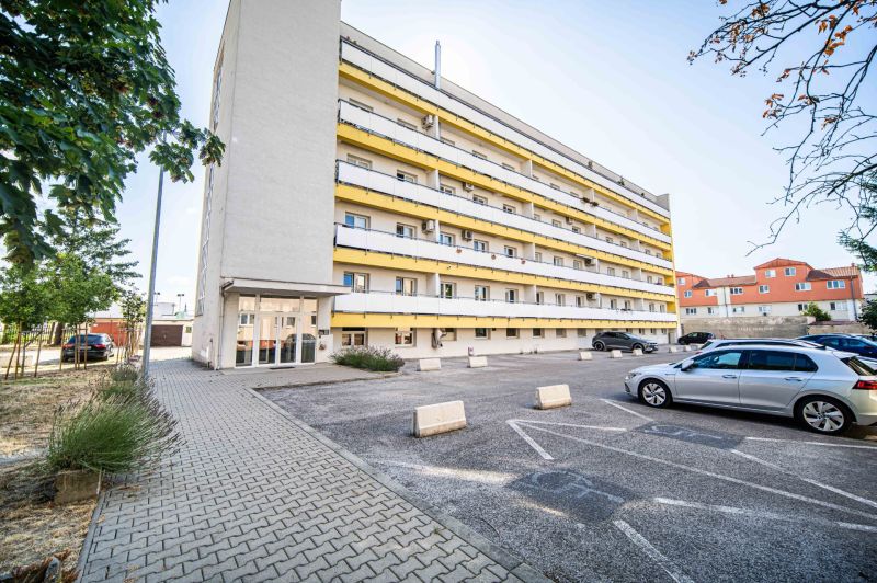 Apartment building on 1. mája in Pezinok with parking in front of 2-bedroom apartments.