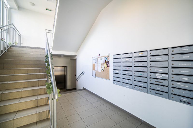 Entrance to the building on 1. mája in Pezinok with mailboxes and staircase.