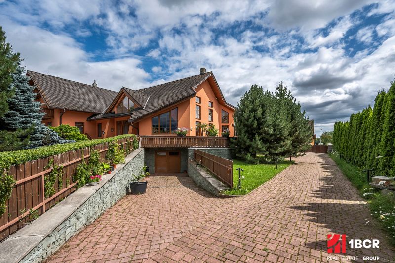 A family house in Veľká Lomnica with a well-maintained garden and a paved driveway.