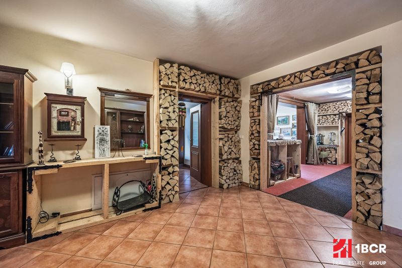 A hallway with a fireplace in a family house, where there is space for storing wood.