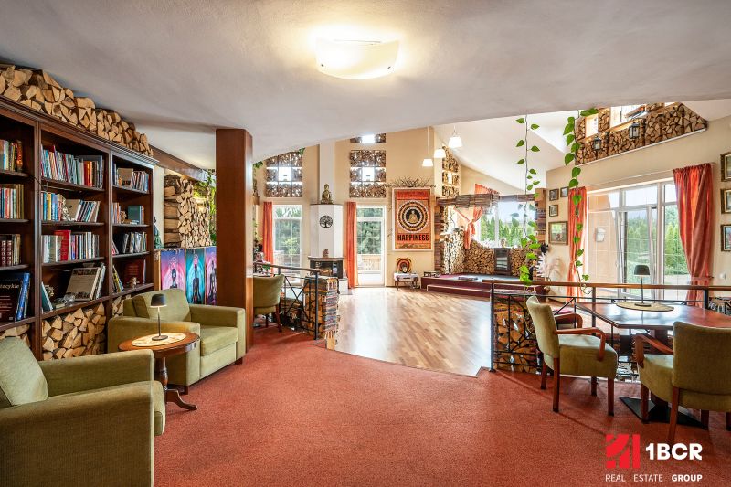 Interior of a family house with a library, comfortable armchairs, and a wooden decor floor.