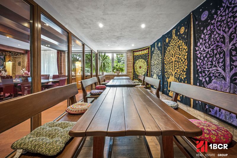 A dining room in a family house with benches and colorful textile decorations on the wall.