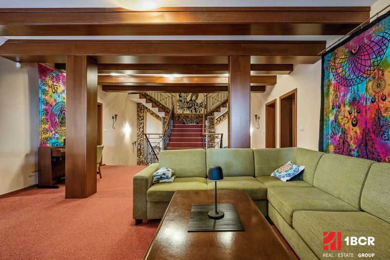 Living room in a family house with colorful textiles, a green sofa, and wooden decorations.