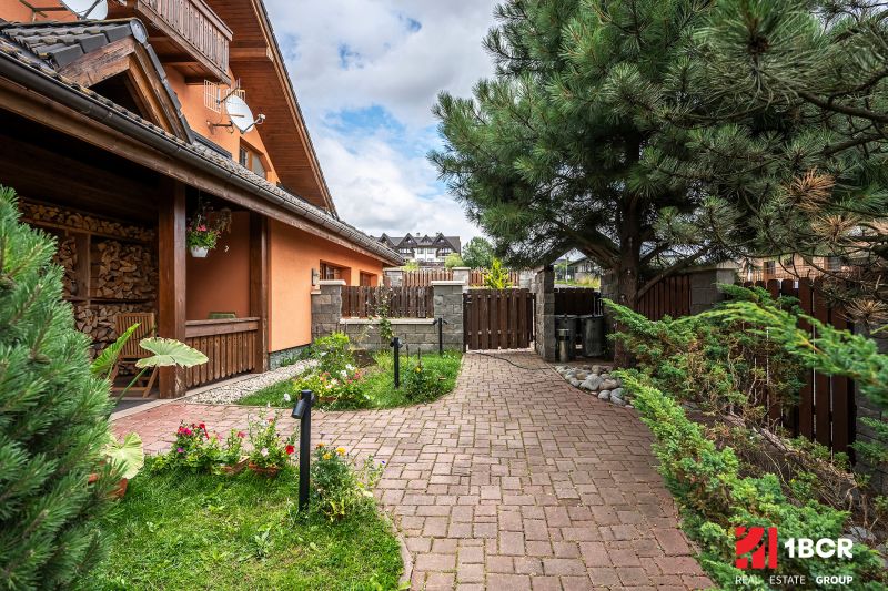 A family house in Veľká Lomnica with a colorful garden and a paved walkway.