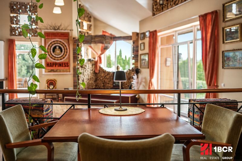 A table with a lamp, a plant, and colorful accessories in a family house with a wood-patterned floor.