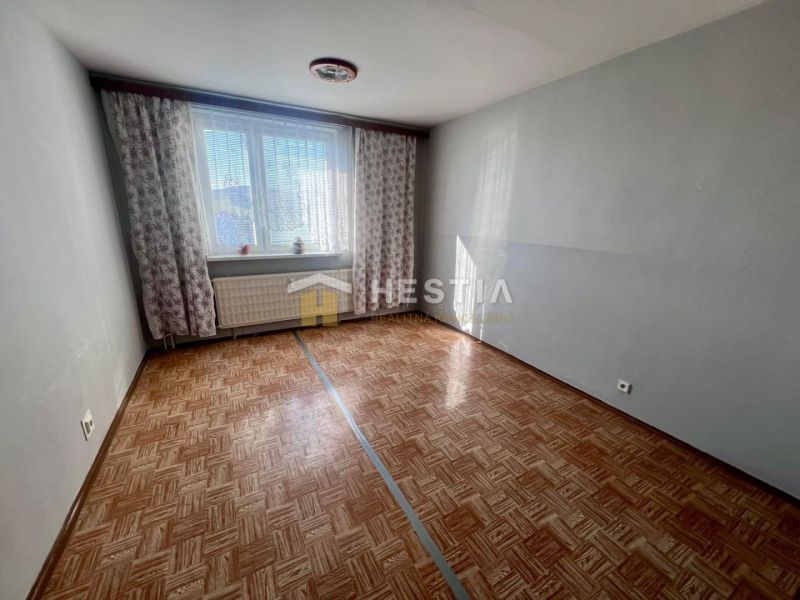 A room with a wooden decor floor in a 3-room apartment.
