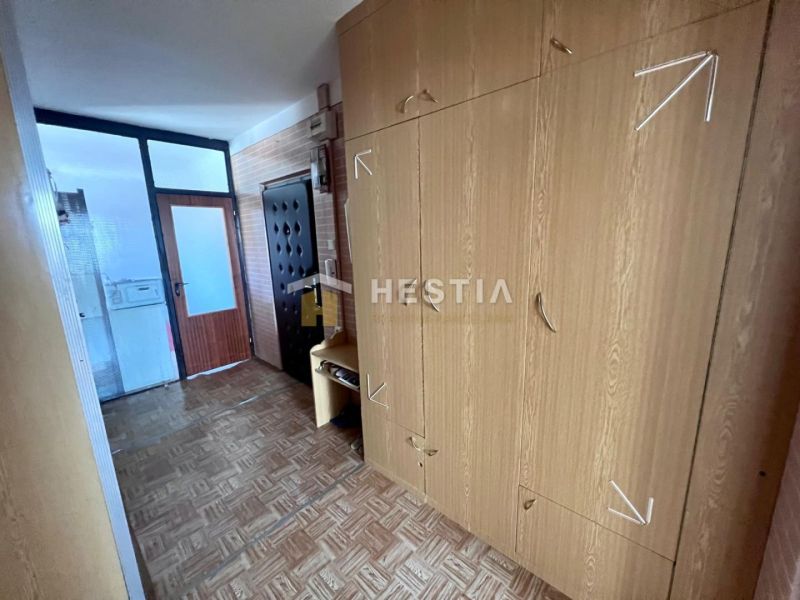 Entrance hall in a 3-room apartment with wood-patterned flooring and built-in wardrobes.