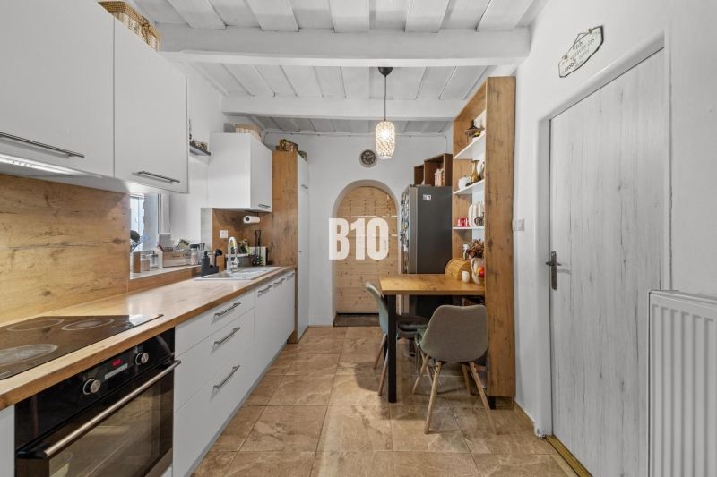 A kitchen in a family house with a wooden decor floor and a dining table.