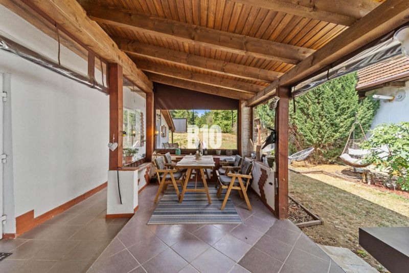 Covered terrace of a family house in Podhájska with a dining table and a hammock.