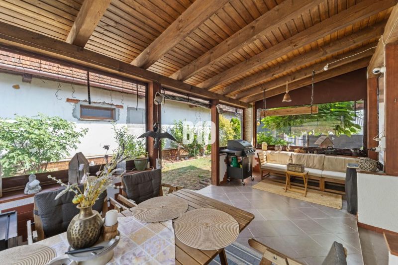 The terrace of a family house in Podhájska with garden furniture and a grill.