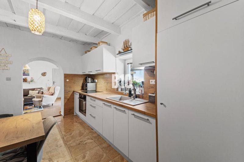 A kitchen in a family house with white cabinets and a wood-patterned floor.