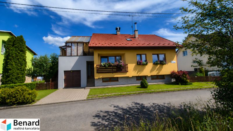 Yellow family house in Podolínec with a red roof and a garden.