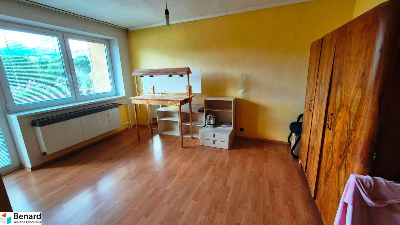 A room with a wooden floor decor, yellow walls, and furniture in a family house.