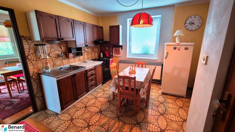Rustic kitchen in a family house with floral wall tiles and flooring.