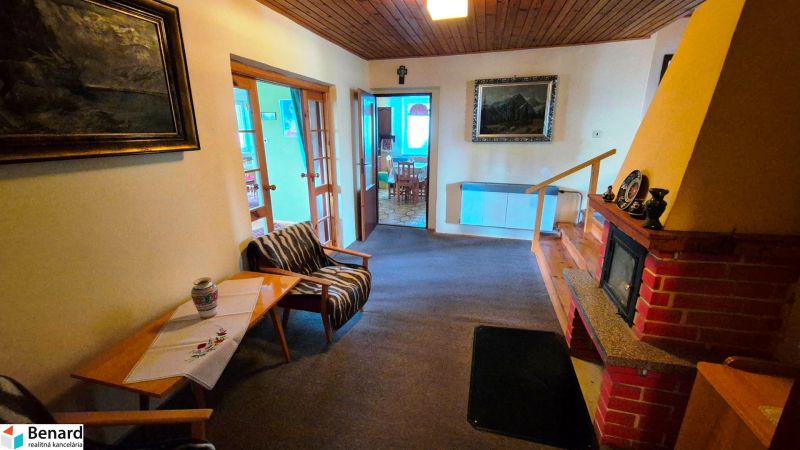 Living room with a fireplace, warm interior, wooden ceiling, family house in Podolínec.
