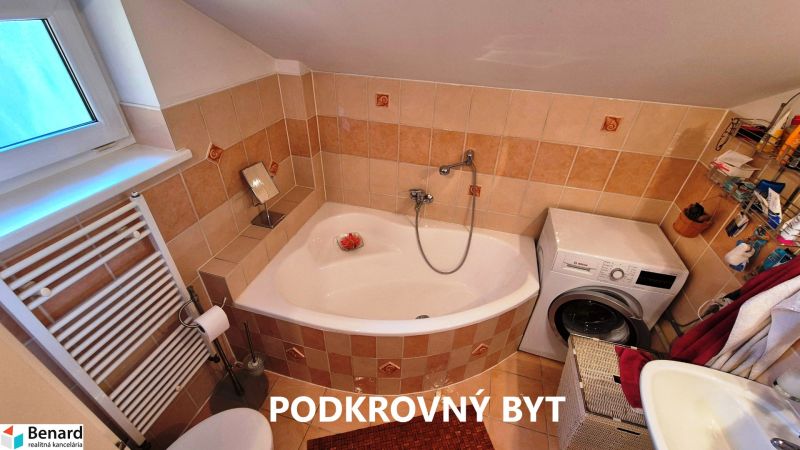 Attic bathroom with a bathtub and a washing machine, attic apartment.