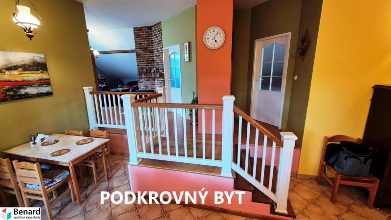 Dining area with table, chairs, and stairs in a family house.