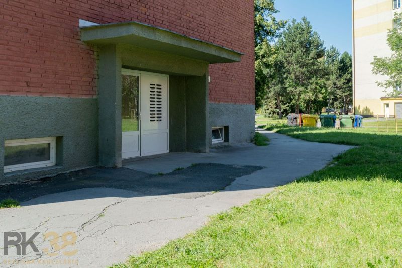 Exterior of a building with a lawn and a walkway in Poprad, near a 1-room apartment.