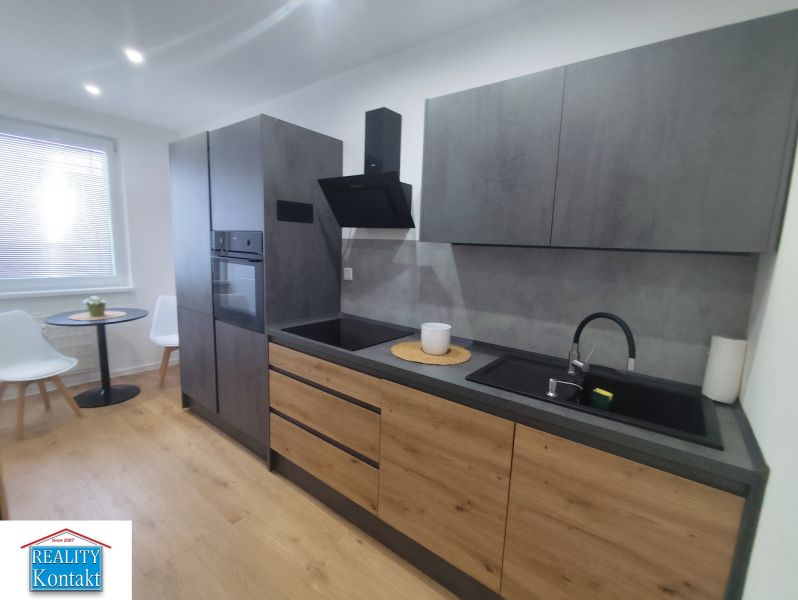 A kitchen in a 3-room apartment with a wooden decor floor and stylish seating.
