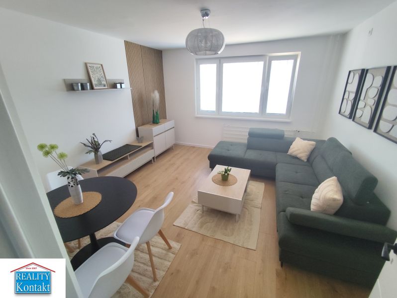 Living room in a three-room apartment with a wooden decor floor and a comfortable sofa.