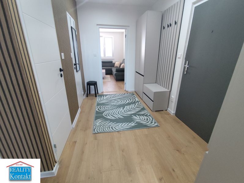 A hallway in a 3-room apartment with a wooden decor floor and modern furnishings.