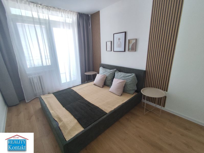 A bedroom in a 3-room apartment with a bed and a floor with a wooden decor.