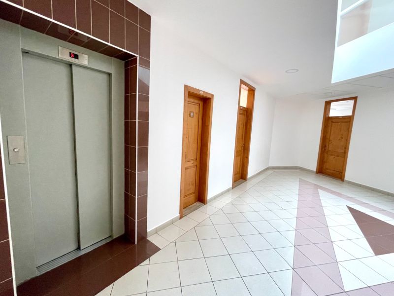 Offices with an elevator and doors, light tiles.
