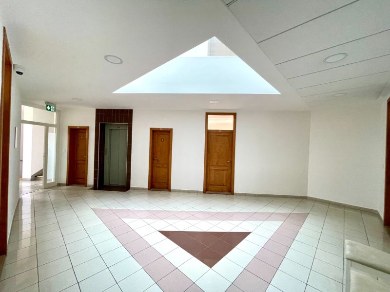 A bright office interior with doors and an elevator, floor with a geometric pattern.