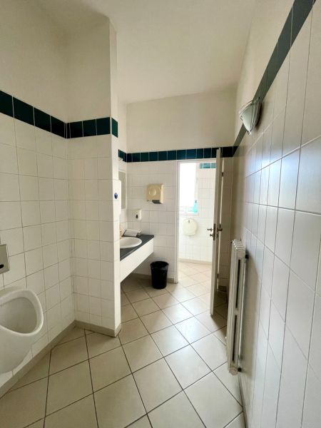 Toilets in offices with tiled walls and floors.