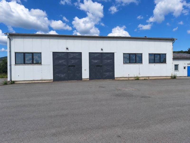 Warehouse and hall building in the village of Ličartovce, with large gates and an asphalt surface.