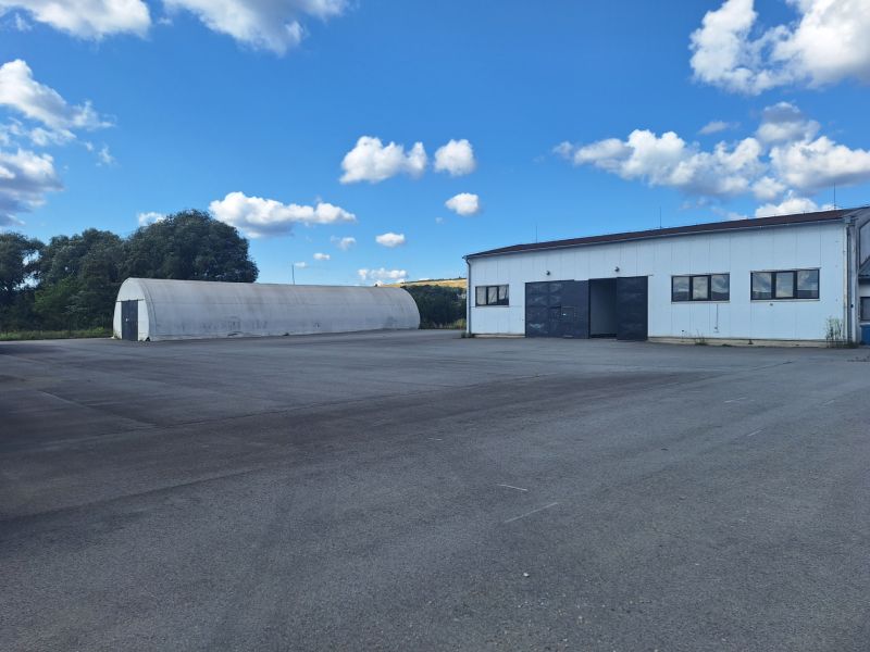 Warehouses and halls in Ličartovce with a spacious outdoor area and a blue sky.