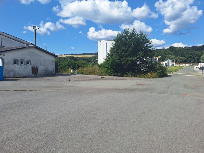 Warehouses and halls in Ličartovce with an asphalt road and greenery in the surroundings.