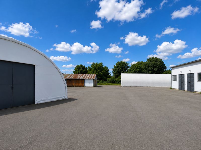 Warehouses and halls in Ličartovce with open space and blue sky.