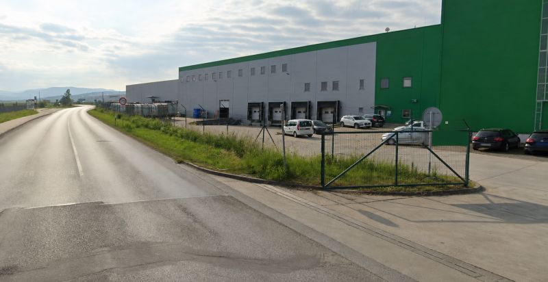 Warehouses and halls in the Záborské district in Prešov by the road with vehicles.