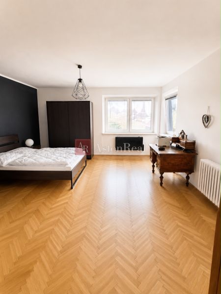 A bedroom with a bed, wardrobe, and wooden decor flooring in a 3-room apartment.