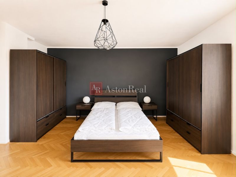 A bedroom in a 3-room apartment with dark furniture and a wooden decor floor.