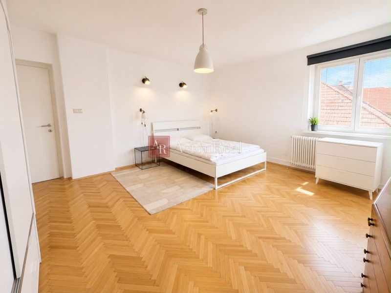 A bedroom in a 3-room apartment with white furniture and a wooden decor floor.