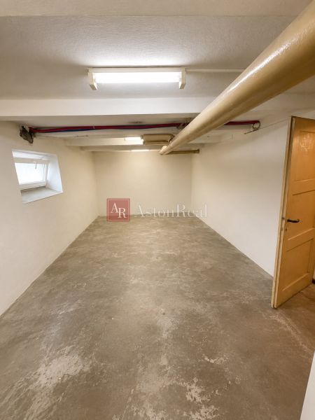 A spacious cellar in a 3-room apartment with a concrete floor and ceiling lighting.