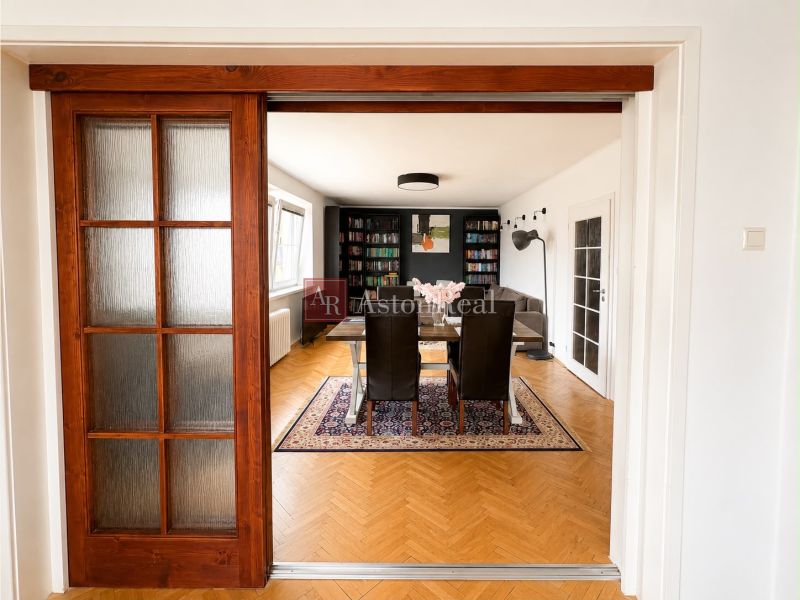 Sliding doors lead to the living room with a wood-patterned floor in a 3-room apartment.